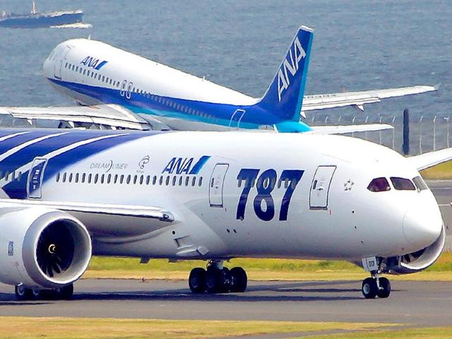The first Boeing 787 plane delivered to a Japanese commercial customer, front, lands at the Tokyo international airport at Haneda, after a flight from Everett, Washington.