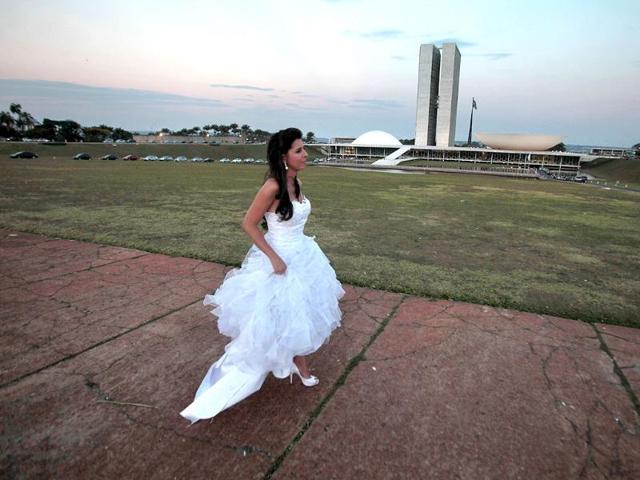 A bride walks to her car after a photo shoot in her wedding gown outside the National Congress in Brasilia, Brazil.