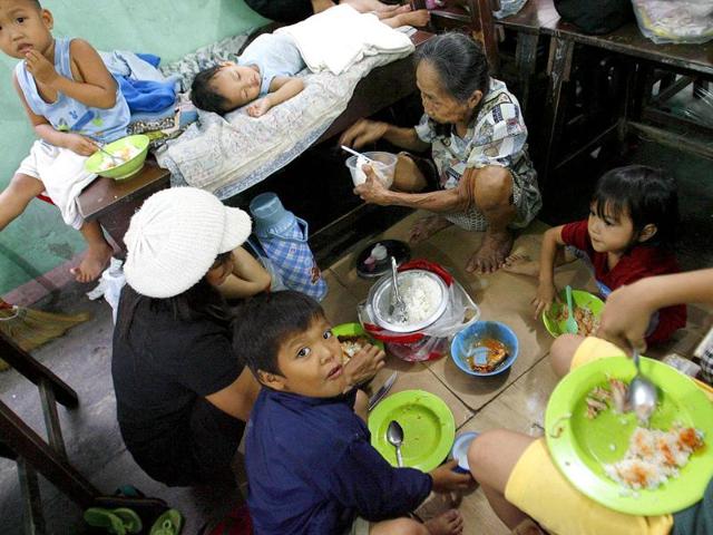 Members of a family share a meal inside a classroom that was turned into a temporary evacuation center after Typhoon Nesat submerged their home in floodwaters in Marikina City, Metro Manila.