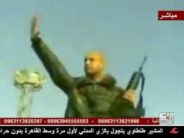 A still image from video broadcast by a Syria-based television station shows what the station describes as Muammar Gaddafi's son Saif al-Islam holding a rifle as he rallies his forces at an unidentified location in Libya.