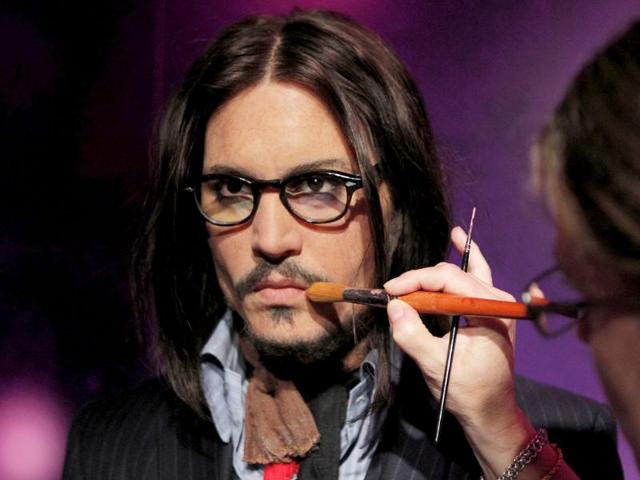 Figure production maintenance manager Petra van der Meer retouches Johnny Depp's wax figure at the Madame Tussauds wax exhibition in Tokyo, Japan.