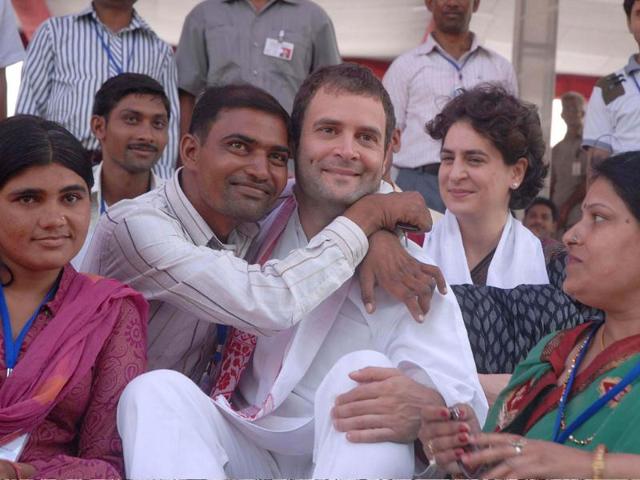 A physically disabled person hugs Congress general secretary Rahul Gandhi as he distributes motorised tri-wheelers in New Delhi; sister Priyanka looks on.