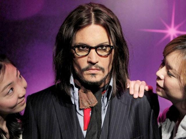 Models pose with Johnny Depp's wax figure at the Madame Tussauds wax exhibition in Tokyo, Japan.