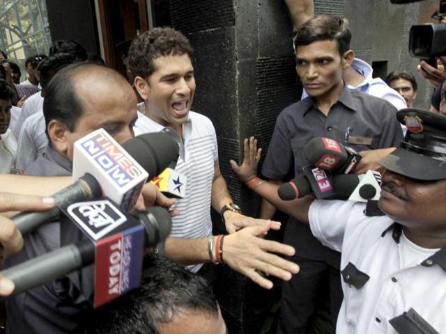 Sachin Tendulkar reacts as he interacts with school children who arrived to greet him after he moved to his new house in Bandra area in Mumbai.