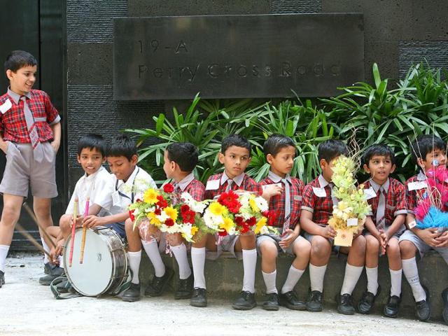 School children wait in front of Sachin Tendulkar's new house at Perry Cross Road in Bandra, Mumbai.