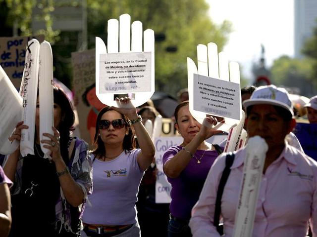 Pro-choice activists hold signs reading "We women from Mexico City already decide freely and voluntarily about our bodies and sexuality" during a protest in Mexico City.