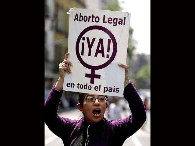 A pro-choice activist holds a sign reading "Legal abortion now in the entire country," during a protest in Mexico City.