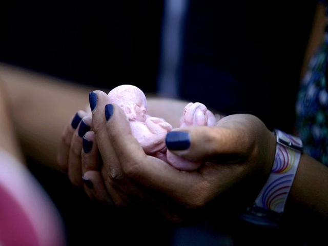 An anti-abortion activist holds clay dolls in the shape of foetuses during a protest in Mexico City.