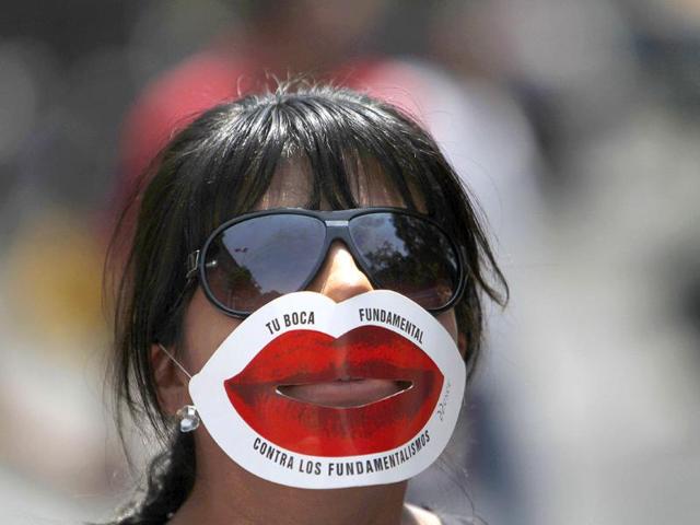 An activist, wearing a mask that reads in Spanish "Your mouth is fundamental against fundamentalism," demonstrates in favor of legalizing abortion in Mexico City.