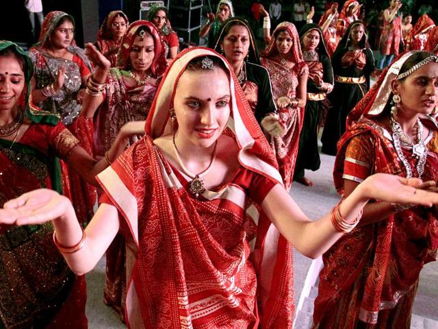 An Italian participant, center in traditional Indian attire performs with others in a rehearsal for Navratri festival celebrations in Ahmadabad.