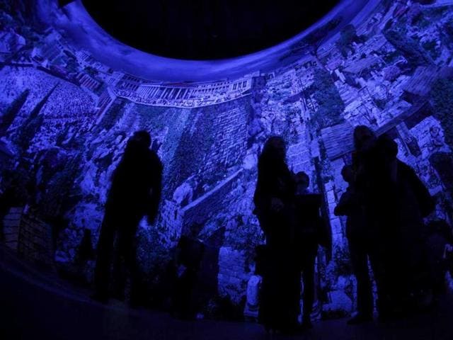 People walk at the 'Pergamon - Panorama of the Ancient Metropolis' 360 degrees panorama created by artist Yadegar Asisi at an exhibition by the Collection of Classical Antiquities - National Museum during the press preview in Berlin. The condensed scenes depicted in Asisi panorama are 30 metres in height and 100 metres in length showing natural landscapes and the acropolis in Pergamon in the year 129 AD.