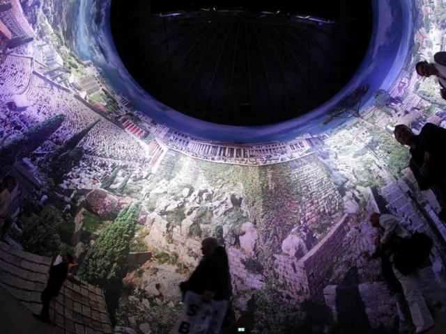 People walk at the 'Pergamon - Panorama of the Ancient Metropolis' 360 degrees panorama created by artist Yadegar Asisi at an exhibition by the Collection of Classical Antiquities - National Museum during the press preview in Berlin. The condensed scenes depicted in Asisi panorama are 30 metres in height and 100 metres in length showing natural landscapes and the acropolis in Pergamon in the year 129 AD.