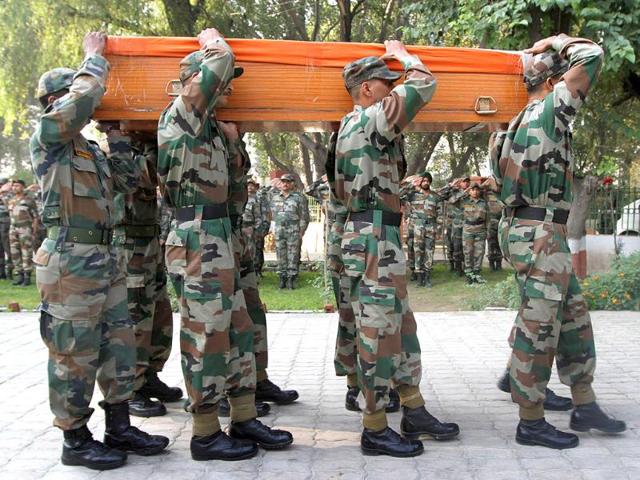 Army soldiers carry a coffin containing the body of soldier Ravi Kumar during a wreath laying ceremony at an army base in Srinagar.