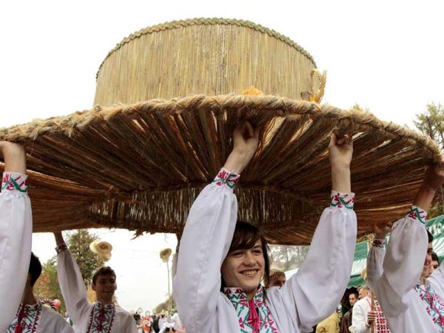 Performers carry a huge hat as they walk in a procession during the Dazhynki harvest festival in Molodechno, near Minsk.
