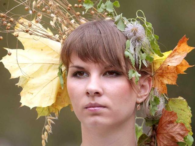 A woman, with autumn leaves in her hair, walks in a procession during the Dazhynki harvest festival in Molodechno, near Minsk.