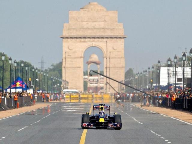 Red Bull Formula One reserve driver Daniel Ricciardo of Australia drives in front of the India Gate during his team's road show in New Delhi.