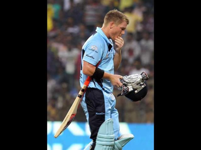 New South Wales batsman David Warner walks off the field after being caught out by Mumbai Indians Harbhajan Singh during their CLT20 match at MA Chidambaram Stadium in Chennai.