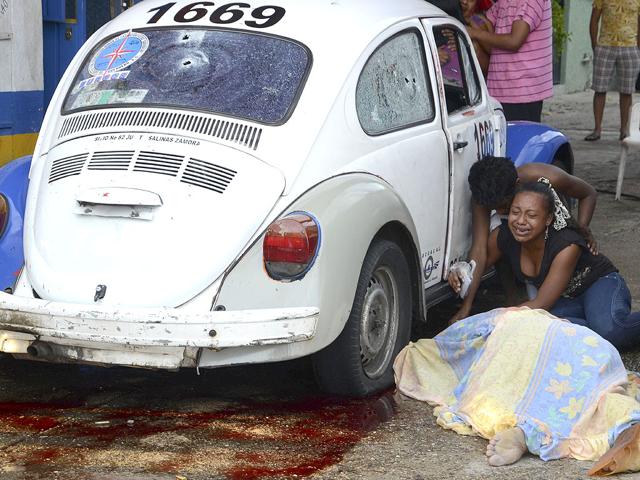 Relatives weep after gunmen opened fire on a taxi killing the driver and the passenger in the Pacific resort city of Acapulco.