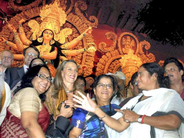 West Bengal chief minister Mamata Banerjee with German tourists celebrates Durga Puja festival in Kolkata.