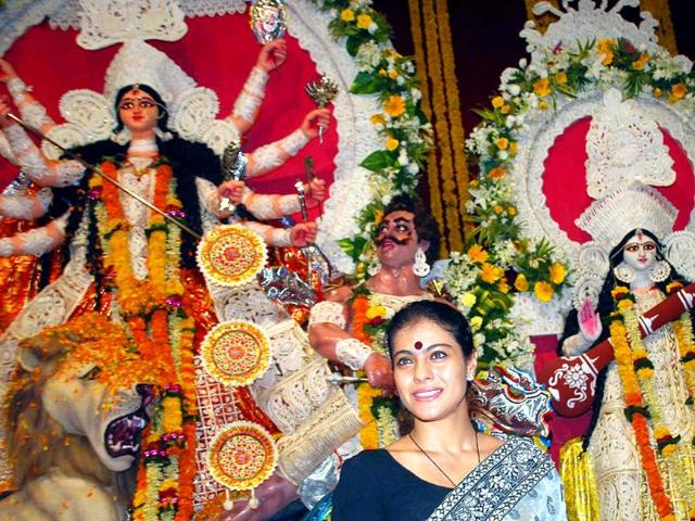 Kajol looks happy in front of the pujo pandal.