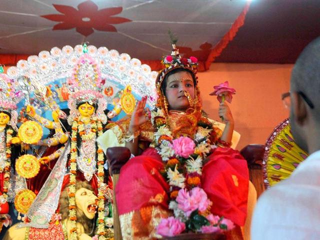A priest performs traditional worship of a Kumari during the religious festival of Durga Puja in Agartala.