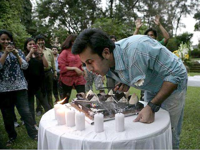 Ranbir blows off the candle before cutting the cake.