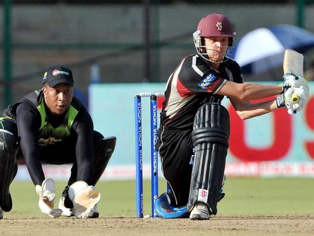 Warriors wicketkeeper Athenkosi Dyili (L) watches as Somerset batsman James Hildreth plays a shot during the Champions League Twenty20 League cricket match between Warriors and Somerset at the M Chinnaswamy Stadium in Bangalore.