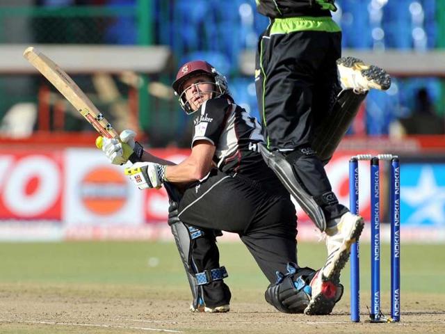 Somerset batsman James Hildreth looks after playing a shot as Warriors wicketkeeper Athenkosi Dyili leaps in the air to stop a ball during the Champions League Twenty20 League cricket match between Warriors and Somerset at the M Chinnaswamy Stadium in Bangalore.