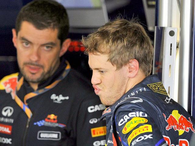 Red Bull-Renault driver Sebastian Vettel (R) of Germany talks with a team official in the pit during the third practice session of the Formula One Japanese Grand Prix at Suzuka.