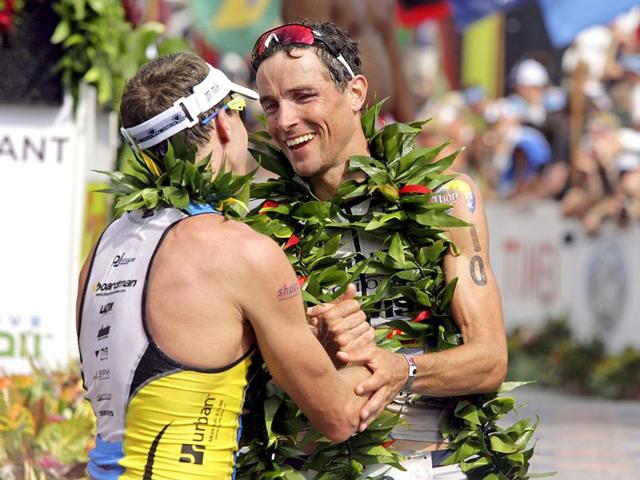 Ironman athlete Pete Jacobs (left) of Australia and Andreas Raelert of Germany congratulate each other after crossing the finish line on Ali'i Drive near the Kailua Pier to place second and third during the Ironman World Championship, in Kailua-Kona, Hawaii.