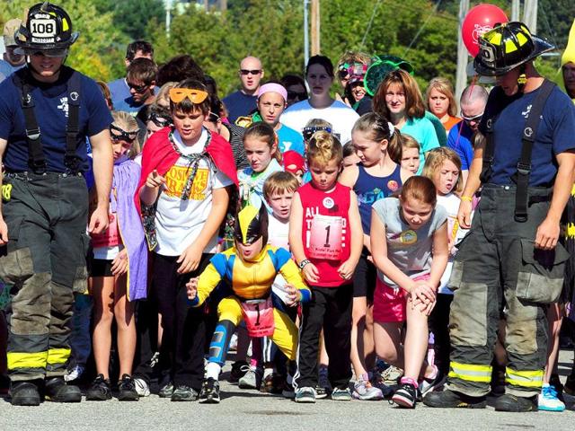 Children and their parents prepare for the start of the superhero-themed Positive Tracks Auburn Firefighters Local 797 Kids' Fun Run in Lewiston, Maine, on the first day of the Dempsey Challenge.