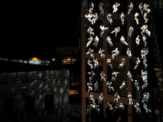 Members of La Fura dels Baus hang in the air in perfect pattern as they rehearse on the eve of Uruguay's Independence bicentennial celebrations in the Independence Square in Montevideo, Uruguay.