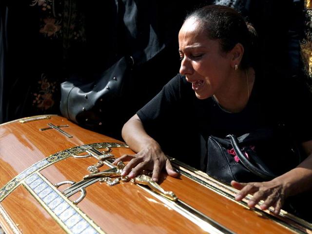 An Egyptian relative of one of the Copts who were killed during clashes with the Egyptian army late Sunday, mourns over his coffin outside the morgue of the Copts hospital in Cairo, Egypt.