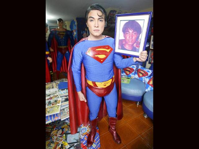 Herbert Chavez holds a photo of himself at 16, taken before his cosmetic transformation to look like his idol Superman, inside his house in Calamba Laguna, south of Manila.