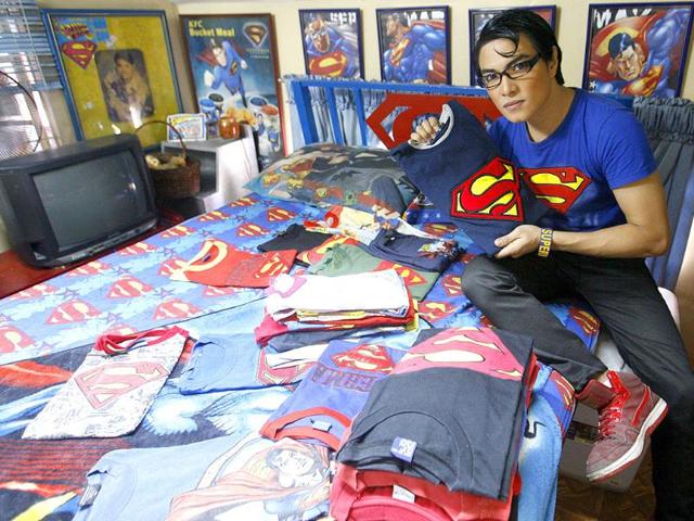 Herbert Chavez shows off his Superman shirt collection, some of which were made by him, inside his bedroom in Calamba Laguna, south of Manila.