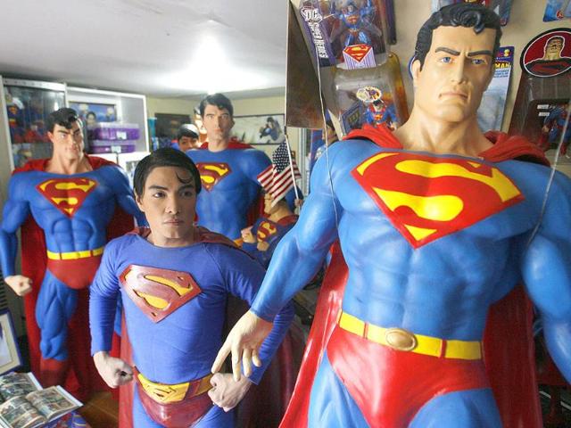 Herbert Chavez poses with his life-sized Superman statues inside his house in Calamba Laguna, south of Manila.