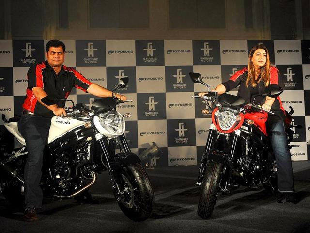 Managing director of India's Garware Motors Diya Garware (R) and chief operation officer Hyder Ali Khan pose with new Hyosung GT 650N super bikes during their launch in Mumbai.