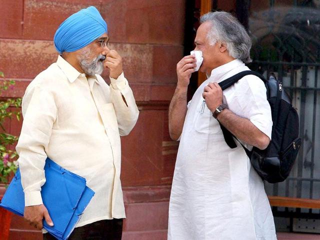 Deputy chairman of Planning Commission Montek Singh Ahluwalia and Union Rural Development minister Jairam Ramesh after a cabinet meeting in New Delhi.
