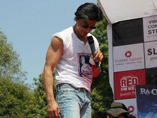 SRK flaunts his muscles by folding the sleeves of his tee.
