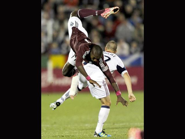 Colorado Rapids forward Omar Cummings (14) flies over Real Salt Lake defender Chris Wingert (17) during the first half of an MLS soccer game in Commerce City, Colo.