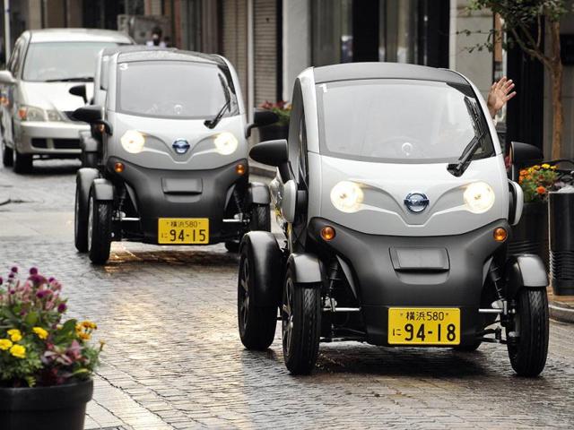 People drive Japanese auto giant Nissan's New Mobility Concept, their two-seat electric vehicle (EV), during a press preview in Yokohama city, suburan Tokyo.