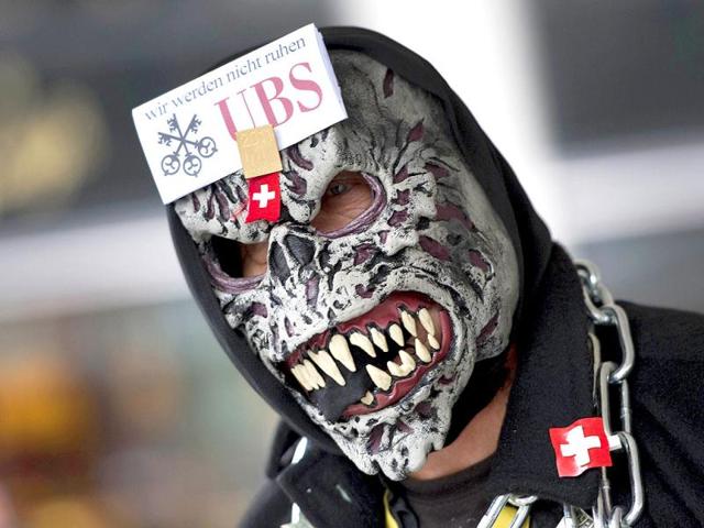 A protester wears a mask bearing the logo of the Swiss Banking giant UBS and a slogan which translates as "We will not rest" participates in a protest as part of a worldwide movement modelled after the anti-Wall Street marches against the banking industry and US authorities. Several hundred demonstrators gathered Zurich's Paradeplatz, the iconic place where both Swiss giant banking UBS and Credit Suisse are located. The Occupy Wall Street protests, which started on September 17 in a New York park, have since spread across the United States.