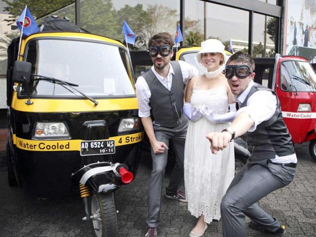 Participants, from left to right, Eoin Pherson of New Zealand, Kristy Ruthen of Australia and Mark Poot of Australia pose near rickshaws before the start of the ASEAN Rickshaw Run in Jakarta, Indonesia.