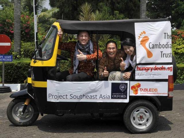 University of Oxford team, Tom Hoogervorst (L) Xin Hui Chan (C) and Pingtjin Thum (R) take off in their auto-rickshaw as they start the 3,000-kilometre ASEAN Rickshaw Run in Jakarta.