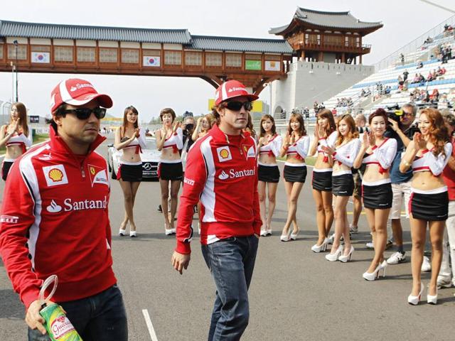Grid girls applaud as Ferrari Formula One drivers Felipe Massa of Brazil (L) and Fernando Alonso of Spain walk out onto the grid for the drivers' parade before the South Korean F1 Grand Prix at the Korea International Circuit in Yeongam.