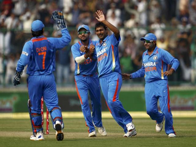 Vinay Kumar celebrates with teammates after dismissing England's captain Alastair Cook during their second one-day international cricket match in New Delhi.