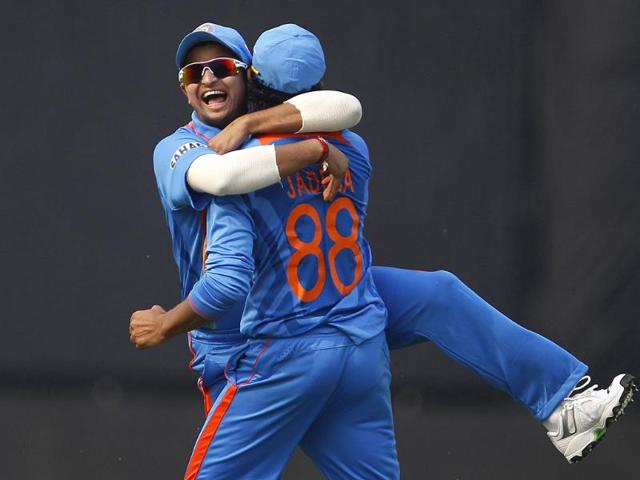 Suresh Raina hugs teammate Ravindra Jadeja to congratulate him on taking the catch to dismiss England's captain Alastair Cook (not seen) during their second one-day international cricket match in New Delhi.
