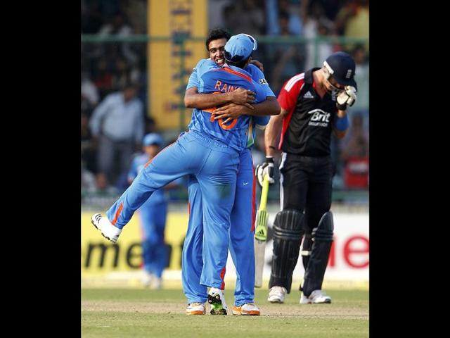 Ravichandran Ashwin embraces teammate Suresh Raina after dismissing England's Ravi Bopara as Kevin Pietersen reacts during their second one-day international cricket match against India in New Delhi.