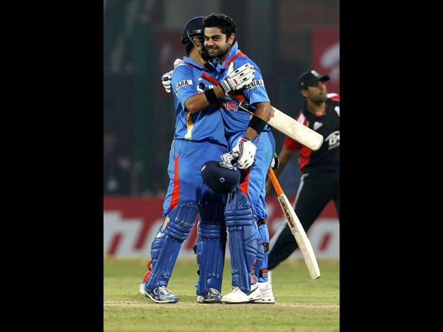 Virat Kohli embraces Gautam Gambhir as he celebrates scoring a century during their second ODI against England in New Delhi.