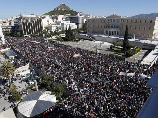 People walk past the Greek parliament during an anti-austerity rally in Athens' Syntagma (Constitution) square. Greek unions begin a 48-hour general strike on the biggest protest in years.